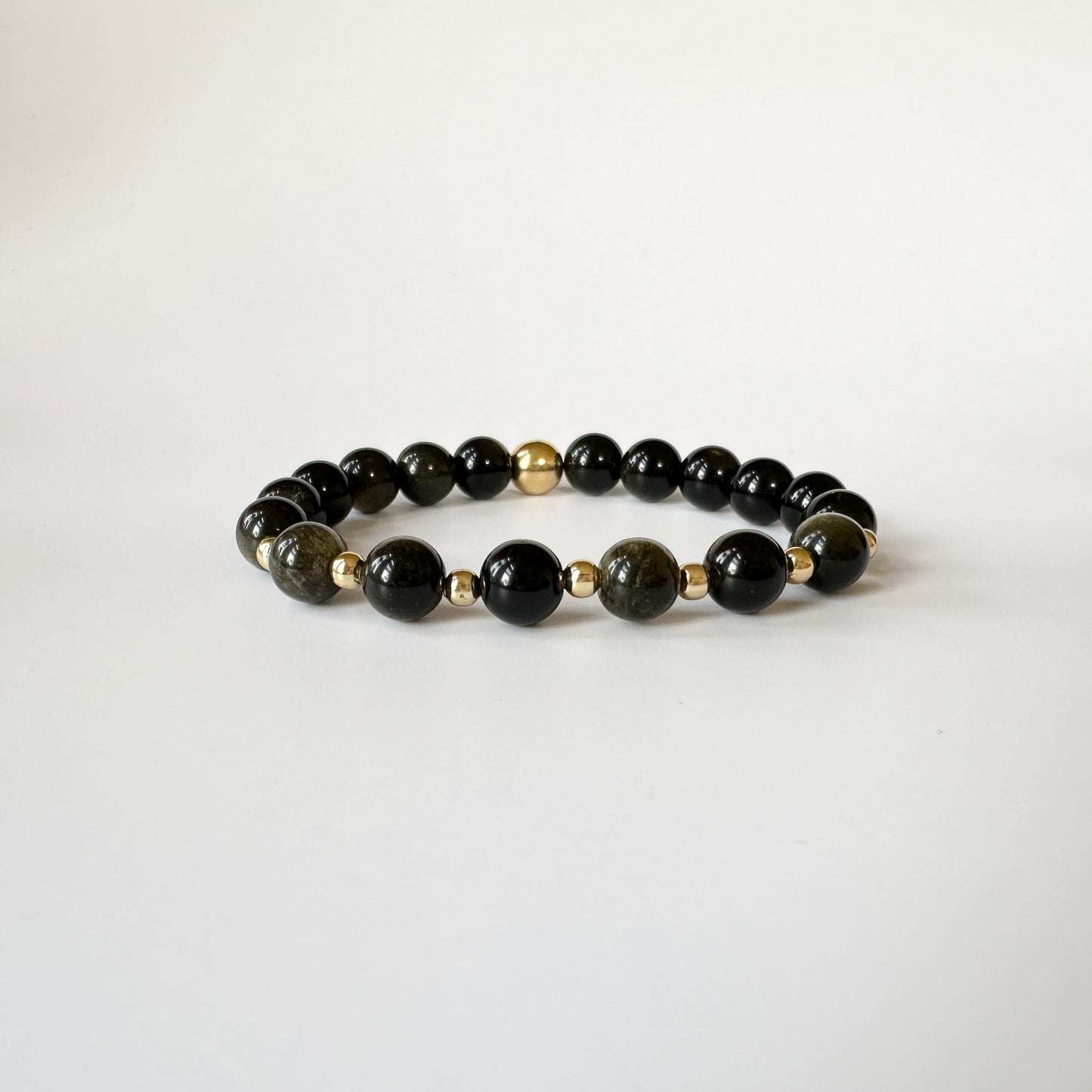 Close-up of polished gold obsidian beads on the Natural Gold Obsidian Bracelets for Couples, showcasing their radiant golden shimmer.