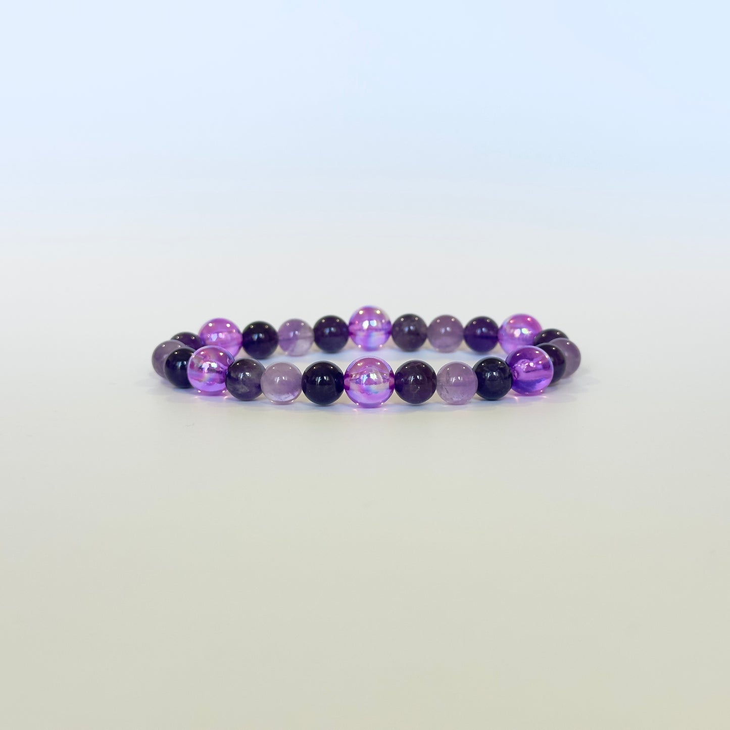 A stunning Natural Amethyst Aura Bracelet featuring deep and light purple Amethyst beads with glowing purple decorative accents, designed for intuition and inner peace.
