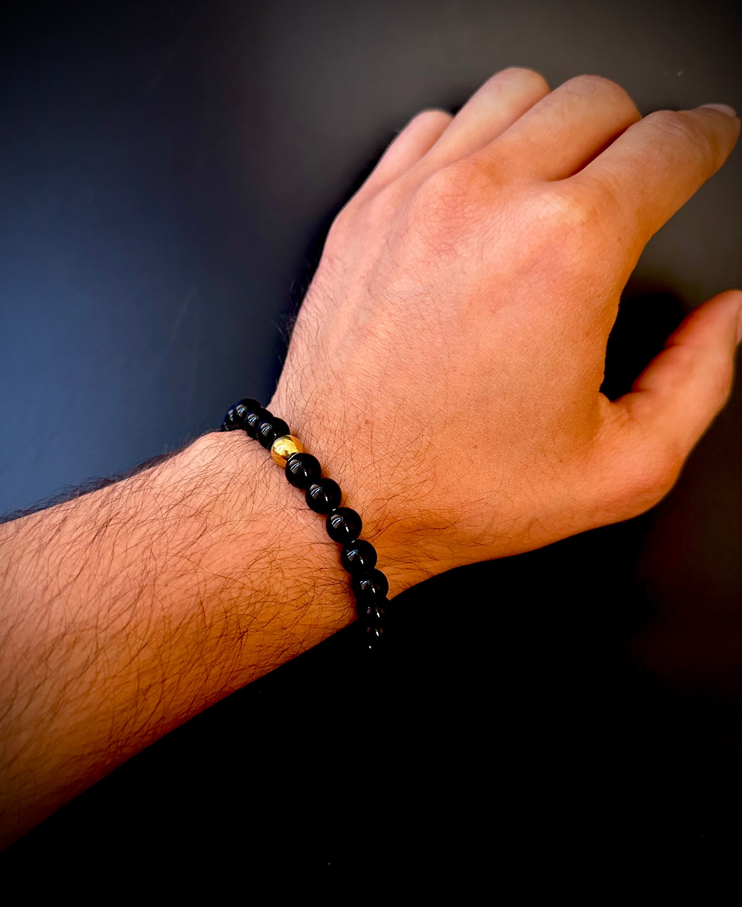 Model wearing the Natural Black Onyx Bracelet for Him, emphasizing its protective and transformative qualities.
