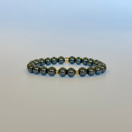 A natural hematite bracelet with a mix of silver and gold-colored beads, presented against a plain background.