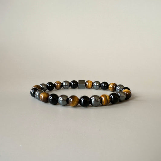 Close-up of polished tiger eye, black onyx, and hematite beads on the Hercules Shield Bracelet.