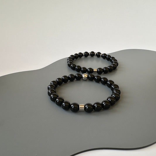 Natural Black Onyx Bracelets for couples with a silver design, symbolizing transformation and protection, displayed on a neutral background.