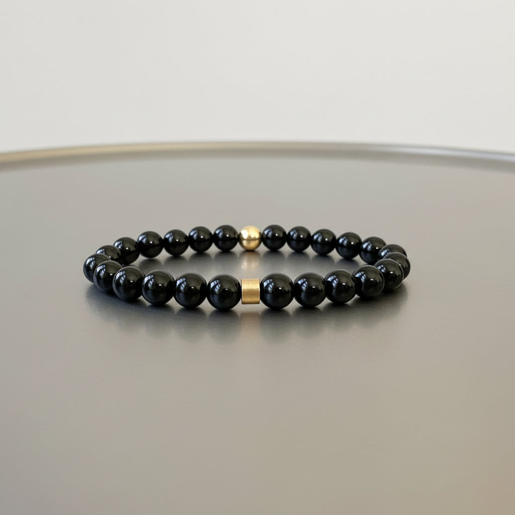Close-up of smooth black onyx beads, showcasing their glossy black surface and timeless beauty.