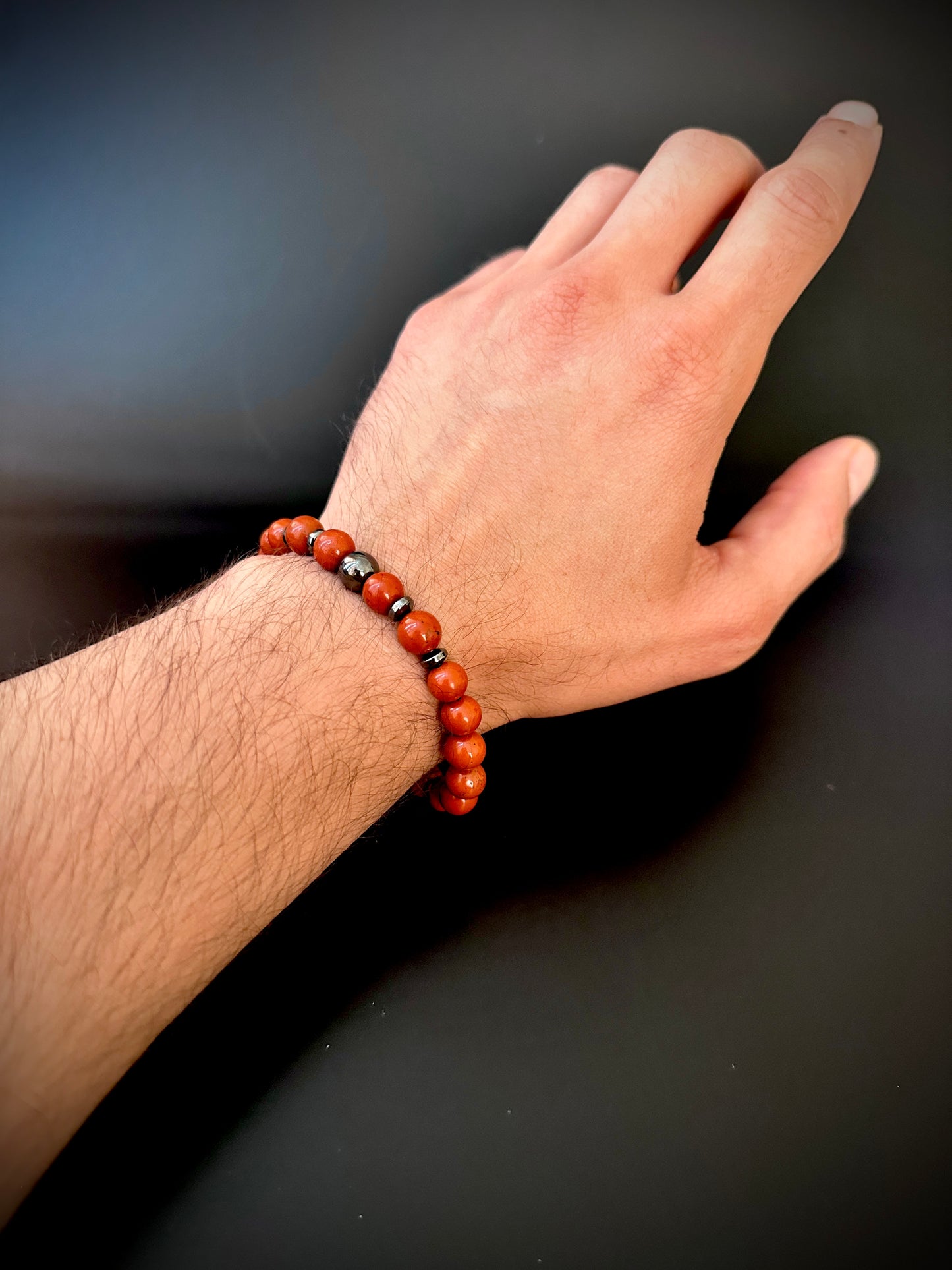 Model wearing the Natural Red Jasper Bracelet for Him, emphasizing its grounding and energizing qualities.